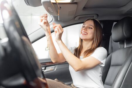 Car interior cleaning, girl worker installs perfume bottleの写真素材