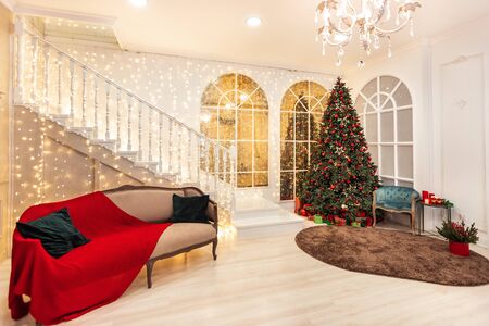 Interior room for New Year Christmas tree and sofa decorated with red balls, stars, illuminations, giftsの写真素材