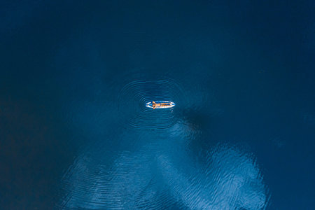 Man lying relax on sup board blue sea water. Aerial top view paddleboard. Freedom concept