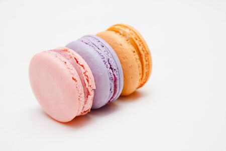 Colorful pink, orange, purple cake macaron or macaroon on white isolated backgroundの写真素材