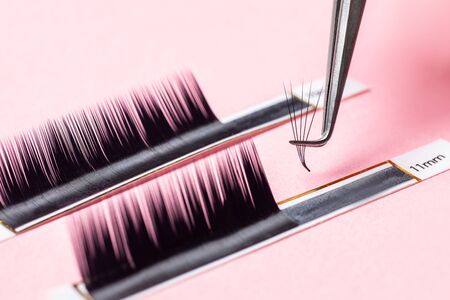 Eyelash extension procedure. Lashes set macro photo, pink backgroundの写真素材