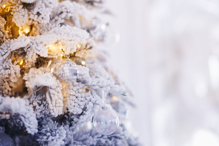 Christmas tree branch with decorations New Year gift ball snowflakes close up, silver white color