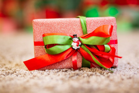 New Year or Christmas gift box with ribbon decorated, background light bokeh