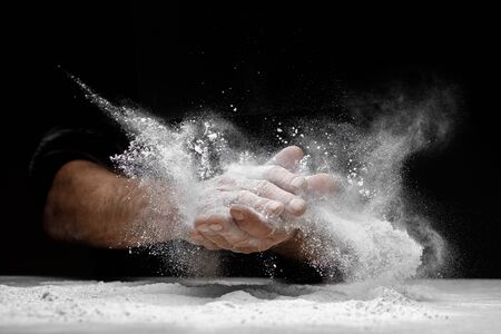 Chef clap white flour dust man hand on black background.の写真素材