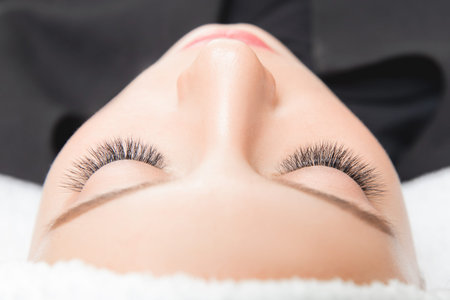 Eyelashes extensions. Lash extension procedure in spa beauty salon.