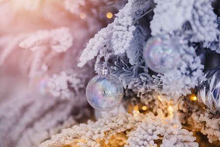 Christmas white tree decorated snow illumination and gifts toys, background light bokeh, silver colorの写真素材