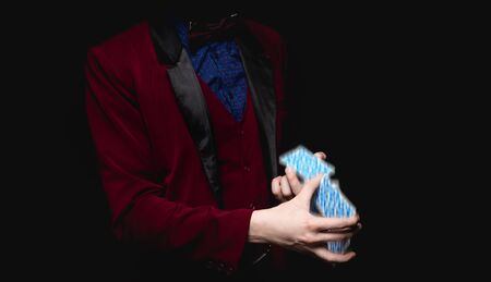 Focus with playing cards in hands of magician, black background close-upの写真素材