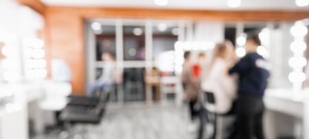 Blurred background beauty salon, master make-up artist, hairdresser girl working with client.の写真素材