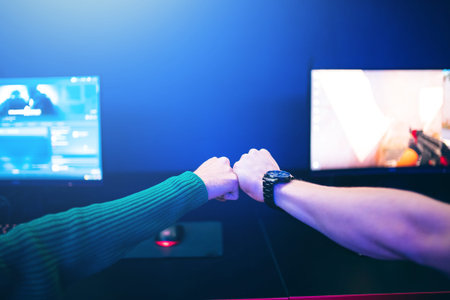Professional gamer greeting and support team fists hands online game in neon color blur background....