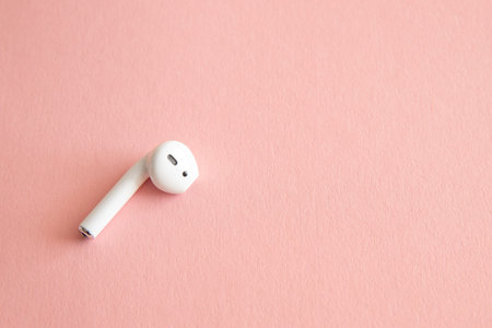 White headphones wireless earphones, copy space pink background