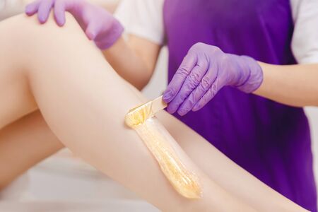 Hair removal procedure sugaring on leg of woman with sugar paste in salonの写真素材