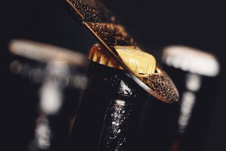 Glass ice cold bottles of beer with opener cap on dark backgroundの写真素材