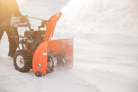 Man cleaning snow from sidewalks with snowblower machine winter.の写真素材