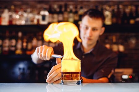 Barman serves whiskey with fire in glass. Dark backgroundの写真素材