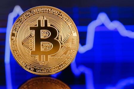 Gold Bitcoin crypto currency on background of chart diagram.の写真素材