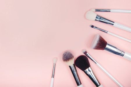 Set makeup brushes on pink color background. Top view point, flat lay.