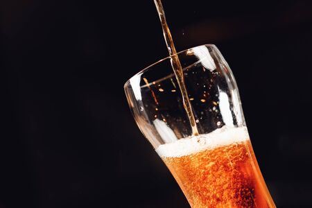 Light Draft cold beer pour in glass from crane in pubの写真素材