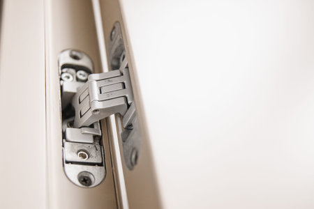 Flush-mounted metal door hinges hidden embedded in wooden canvas.
