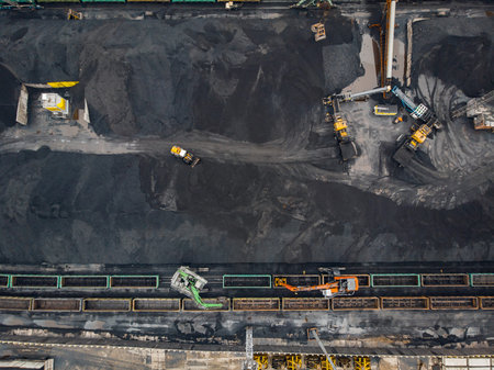 Loading coal anthracite mining in port on cargo tanker ship with crane bucket of train. Aerial top...