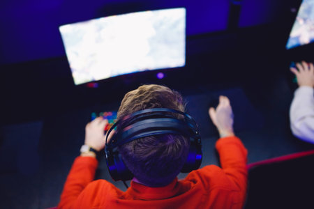 Professional gamer playing online games tournaments pc computer with headphones, Blurred red and...