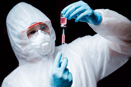 Medic man in white hazmat protective respirator glasses hold blood test epidemic virus positive with...