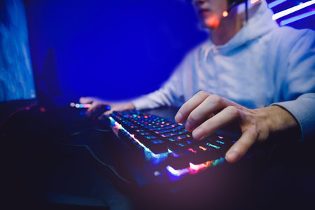 Streamer young man rejoices in victory professional gamer playing online games computer with...