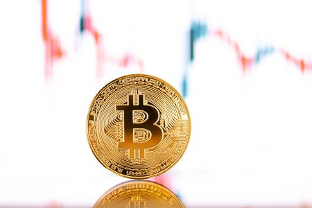 Gold Bitcoin crypto currency on background of chart diagramの写真素材