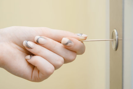 Woman hand presses elevator button with sweep. Concept coronavirus disinfection
