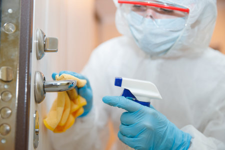 Disinfection and cleaning door handles of house from infection with virus and microbes in...