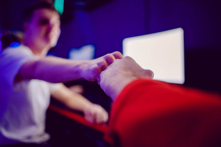 Professional gamer greeting and support team fists hands online game in neon color blur background....