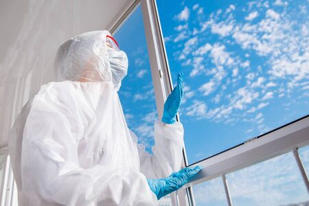 Tired doctor biohazard after hard shift in hospital, coronavirus looks at blue skyの写真素材