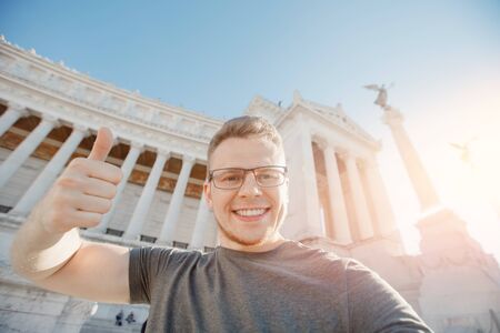 Happy male tourist taking selfie photo on background Venice Square in Rome Italy, blue sky. Travel conceptの写真素材