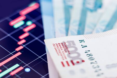 Russian ruble banknotes against backdrop of falling red currencies graphic. Concept economic default, oil.の写真素材