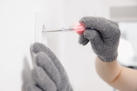 Electrician checks device for electricity voltage power outlet sockets