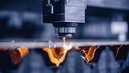 Blue color Laser CNC cut of metal with light spark, technology modern industrialの写真素材