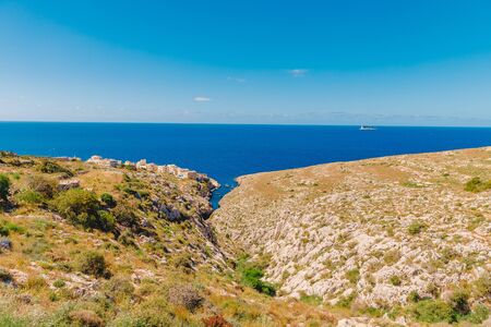 Blue Grotto in Malta. Pleasure boat with tourists runs. Natural arch window in rockの写真素材