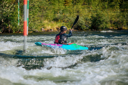 Guy in kayak sails mountain river. Whitewater kayaking, extreme sport rafting.