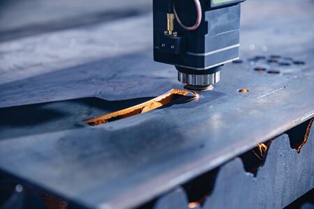 CNC gas cutting metal sheet, sparks fly. Blue steel color, modern industrial technologyの写真素材