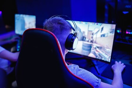 Professional cyber video gamer studio room with computer for stream in neon blue red color blur background. Soft focus.の写真素材
