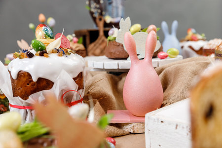 Easter cake orthodox sweet bread kulich and colorful chocolate eggs on festive table.