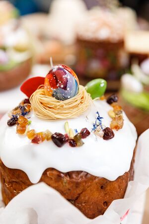 Easter cake orthodox sweet bread kulich and colorful chocolate eggs on festive table.の写真素材