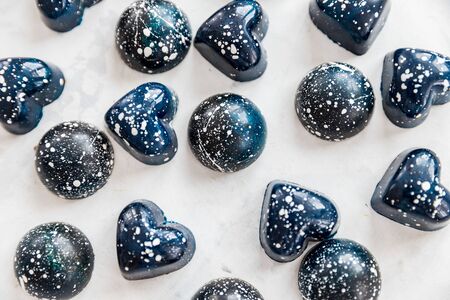 Close-up chocolate candies of blue color with white splashes under stone, top view.の写真素材