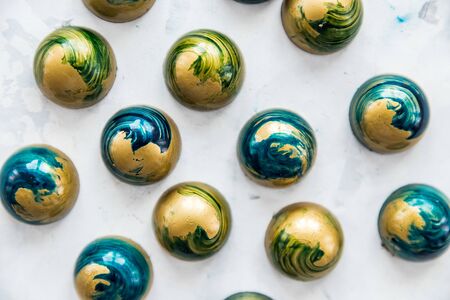 Close-up chocolate candies of blue color with white splashes under stone, top view.の写真素材