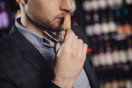 Professional sommelier waiter examining smell of wine corkの写真素材