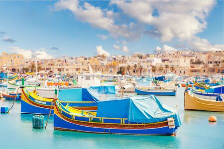 Mediterranean traditional fishing boats retro colorful on Marsaxlokk harbor Malta summerの写真素材