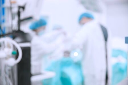 Abstract medical blurred background of operating room, patient lies on table, doctors working.の写真素材