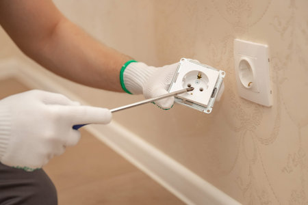 Sockets outlet install Electrician man builder working at home.