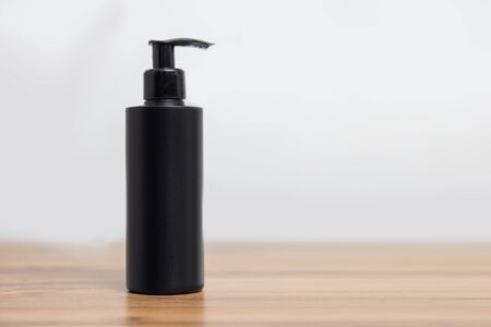 Black bottle mockup for cosmetics shampoo on simple white backgroundの写真素材