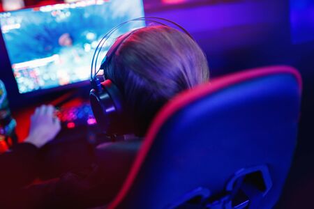 Professional cyber video gamer studio room with computer for stream in neon blue red color blur background. Soft focusの写真素材