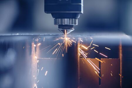 Laser CNC cut of metal with light spark, technology modern industrial. Blue color steelの写真素材